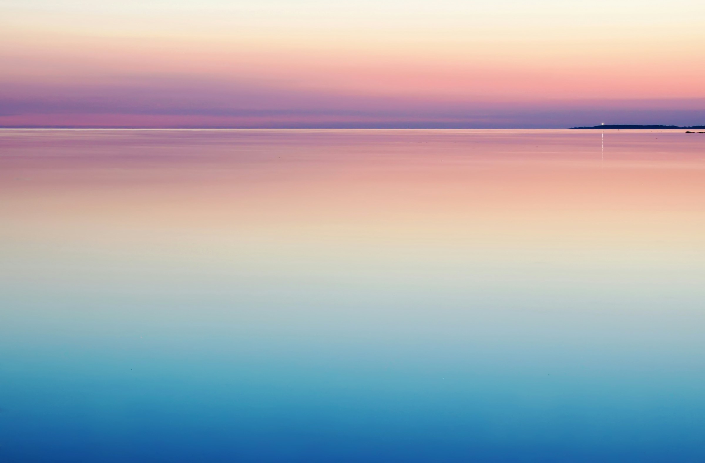 Lever du jour sur une mer calme, une île à l'horizon